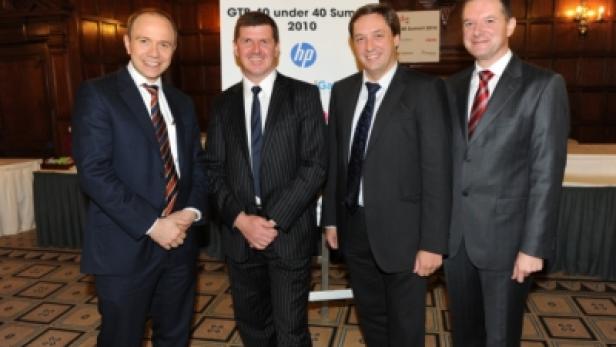 Vier Männer in Anzügen posieren vor einem Schild für den „GTI 40 under 40 Summit 2010“.