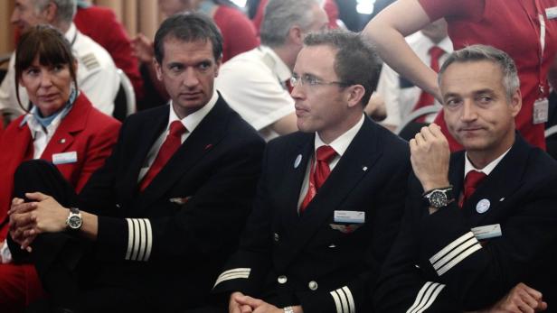 Eine Gruppe von Piloten und Flugbegleitern in Uniformen sitzt zusammen.