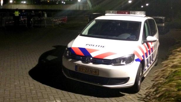 Ein weißer VW Touran der niederländischen Polizei steht nachts auf einem Parkplatz.