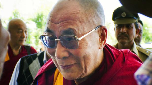 Der Dalai Lama mit Brille, umgeben von Menschen.