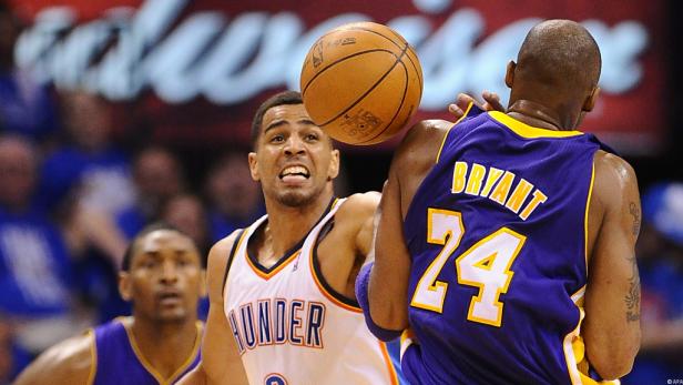 Ein Basketballspieler der Oklahoma City Thunder versucht, den Ball an Kobe Bryant vorbei zu spielen.