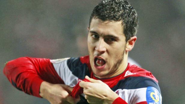 Ein Fußballspieler mit offenem Mund hält sein Trikot fest.