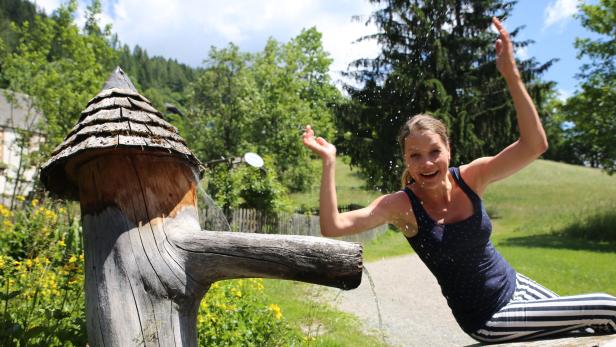 Ein alter Holzbrunnen sorgt an diesem heißen Sommertag für Erfrischung. Die gebürtige Oberösterreicherin lebt in Wien und Berlin – umso mehr genießt Chris Pichler die Ruhe und die Natur in Bad Kleinkirchheim