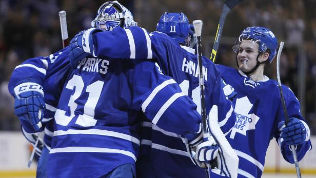 Eishockeyspieler der Toronto Maple Leafs umarmen sich auf dem Eis.