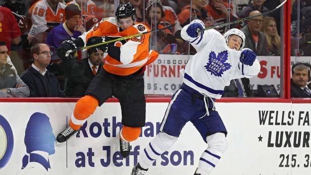 Zwei Eishockeyspieler kämpfen um den Puck.