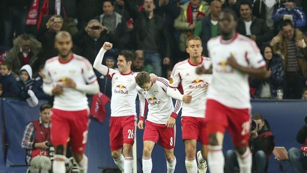 Fußballspieler von RB Leipzig feiern auf dem Spielfeld.