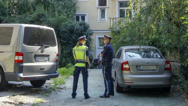 Zwei Polizisten stehen zwischen einem VW-Bus und einem Skoda Octavia.