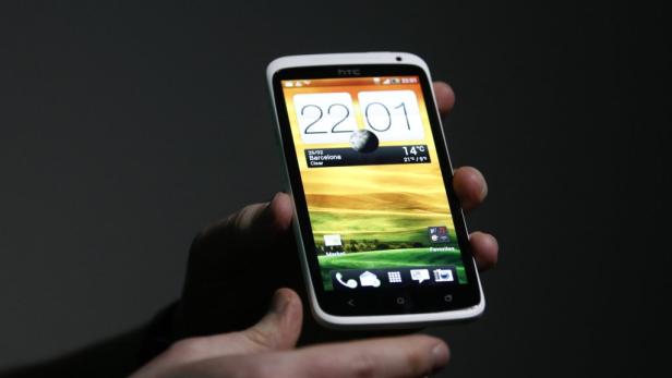 Ein HTC-Smartphone mit einer Wetter-App wird in der Hand gehalten.
