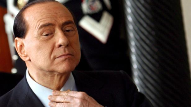 Silvio Berlusconi richtet seinen Kragen.