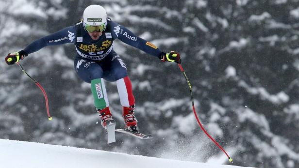 Ein Skirennläufer springt während eines Rennens über eine Kuppe.