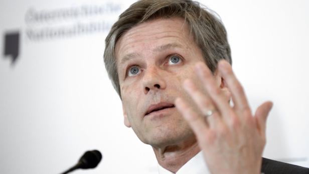 Ein Mann spricht vor einem Mikrofon und gestikuliert mit der Hand.