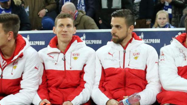 Mehrere Fußballspieler des VfB Stuttgart sitzen auf der Bank.