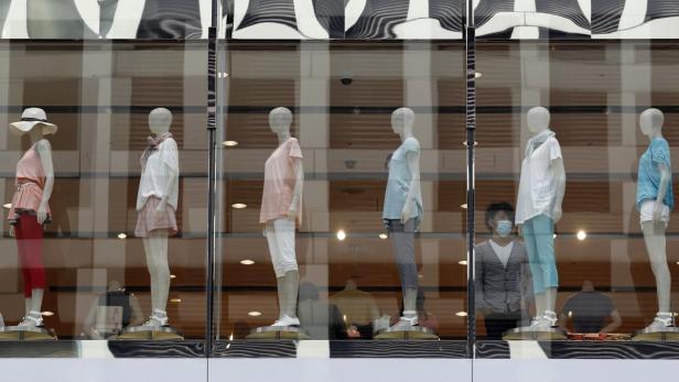 Ein Schaufenster mit mehreren Schaufensterpuppen, die Sommerkleidung präsentieren.