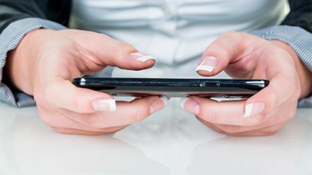 Eine Frau hält ein Smartphone in ihren Händen.