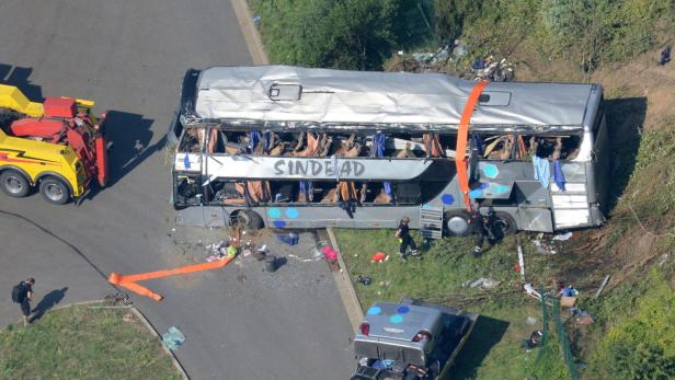 Ein schwer beschädigter Reisebus nach einem Unfall wird von einem Abschleppwagen geborgen.
