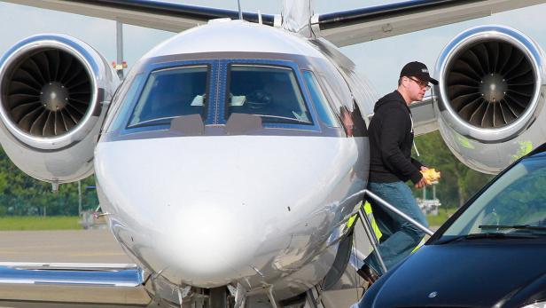 Matt Damon steigt mit einem gelben Spielzeug in der Hand aus einem Privatjet.