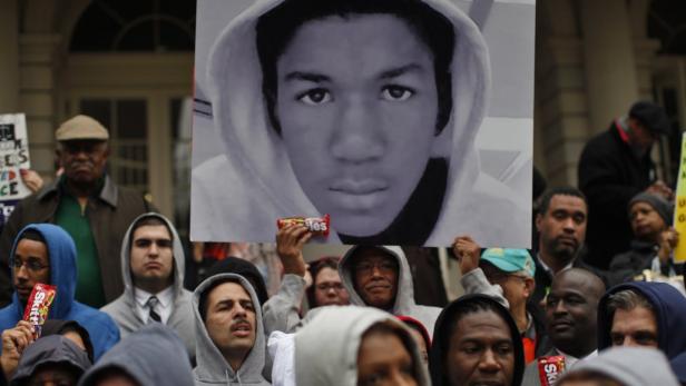 Eine Menschenmenge demonstriert mit einem Bild von Trayvon Martin und Süßigkeiten.