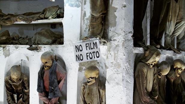 Mumifizierte Leichen in den Katakomben von Palermo, mit einem Schild, das das Fotografieren verbietet.