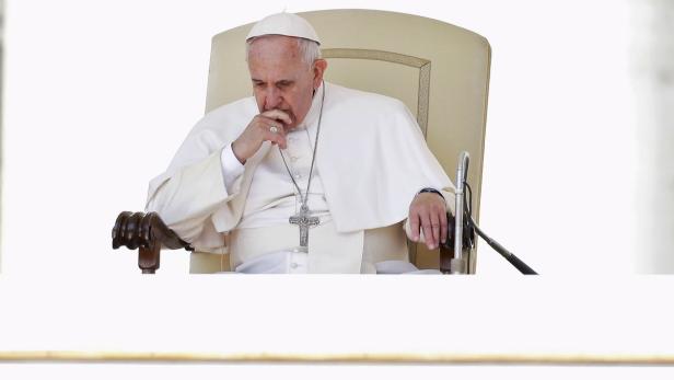 Papst Franziskus sitzt nachdenklich auf einem Stuhl.