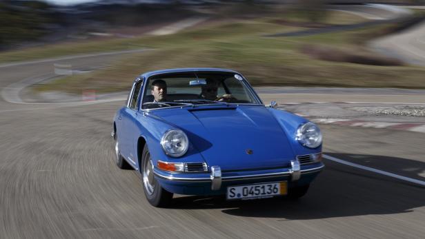 Ein blauer Porsche 911 fährt auf einer Rennstrecke.