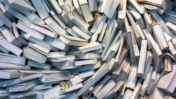 Ein großer Haufen weißer Bücher liegt übereinander.