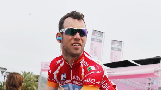 Ein Radrennfahrer in roter Rennbekleidung und Sonnenbrille.