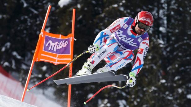 Ein Skirennfahrer in Frankreich-Farben fährt einen Hang hinunter.