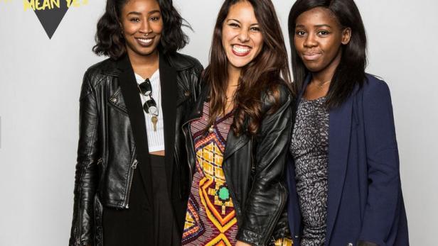 Drei junge Frauen posieren vor einer Wand mit dem Hashtag „This Doesn't Mean Yes“.