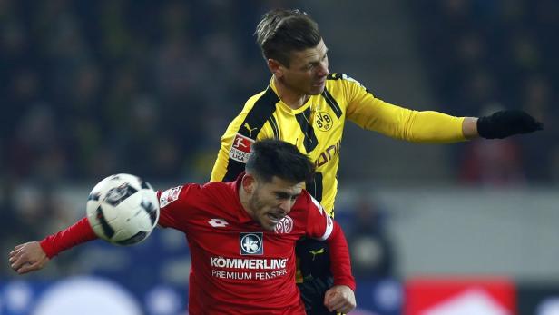 Zwei Fußballspieler kämpfen um den Ball.