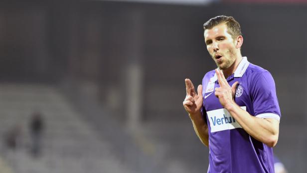 Ein Fußballspieler in lila Trikot gestikuliert auf dem Spielfeld.