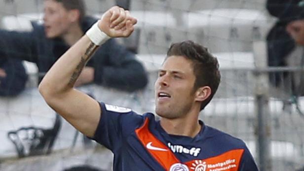 Ein Fußballspieler jubelt mit erhobener Faust auf dem Spielfeld.