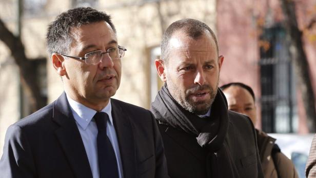 Zwei Männer in Anzügen gehen auf der Straße.