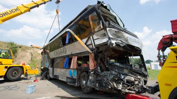 Ein schwer beschädigter „Sindbad“-Doppeldeckerbus wird von einem Kran angehoben.
