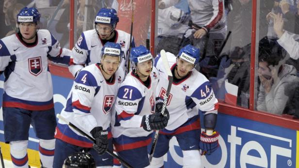 Slowakische Eishockeyspieler stehen am Spielfeldrand.