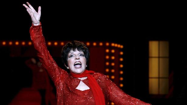 Liza Minnelli tritt in einem roten, glitzernden Kleid auf einer Bühne auf.