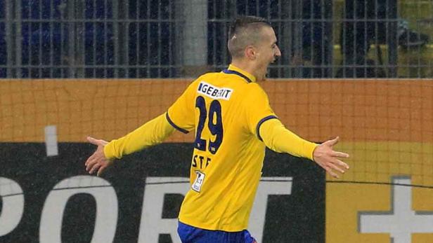 Ein Fußballspieler mit gelbem Trikot und der Nummer 29 jubelt auf dem Spielfeld.