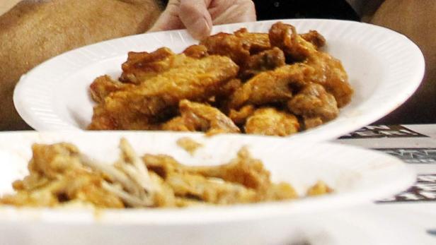 Ein Teller mit Chicken Wings, von denen einige bereits gegessen wurden.