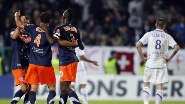 Fußballspieler von Montpellier feiern ein Tor, während ein Spieler von Rennes enttäuscht ist.