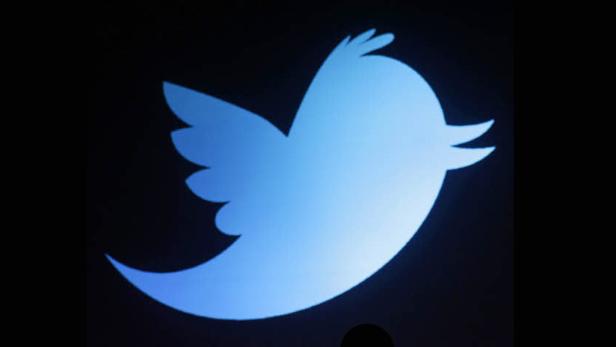 Das stilisierte, blaue Vogellogo von Twitter auf schwarzem Hintergrund.