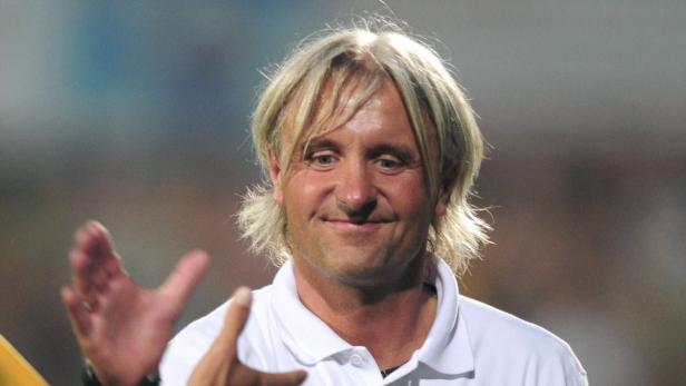 Ein Mann mit blonden Haaren lächelt in die Kamera.