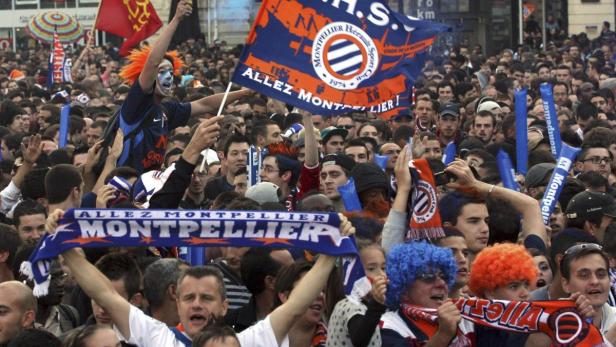 Eine Menschenmenge feiert mit Fahnen und Schals des Montpellier Hérault Sport Club.