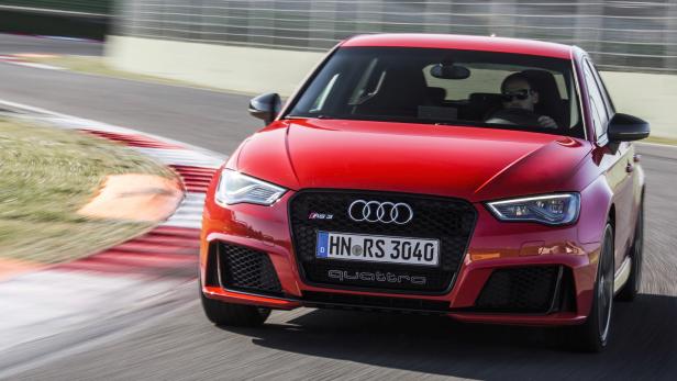 Ein roter Audi RS 3 fährt auf einer Rennstrecke.