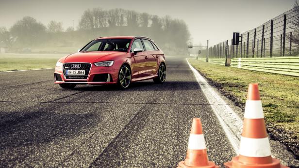 Ein roter Audi RS 3 steht auf einer Rennstrecke.