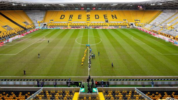 Das Dynamo-Dresden-Stadion mit gelben Sitzen und dem Schriftzug „Dresden“.
