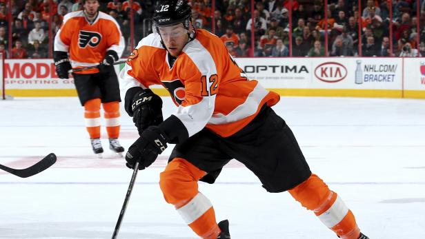 Ein Eishockeyspieler der Philadelphia Flyers mit der Nummer 12 auf dem Eis.