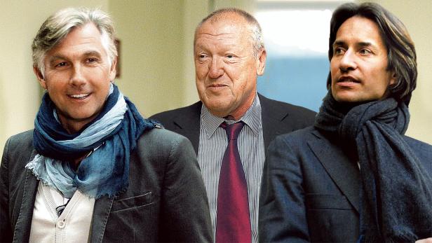 Drei Männer in Anzügen und Schals stehen nebeneinander.