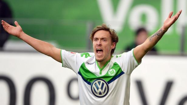 Ein Fußballspieler des VfL Wolfsburg jubelt mit erhobenen Armen.