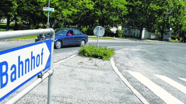 Ein blaues Schild mit der Aufschrift „Bahnhof“ weist den Weg.