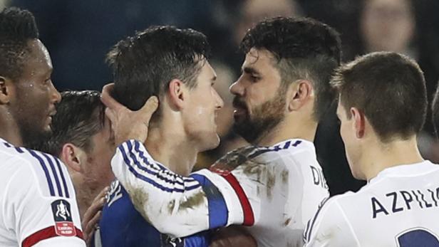 Mehrere Fußballspieler umarmen sich auf dem Spielfeld.