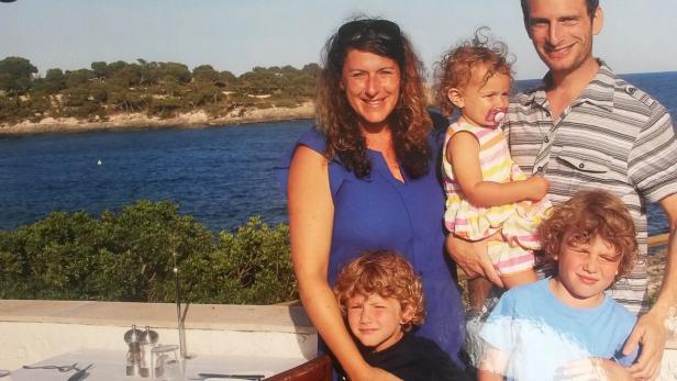 Eine Familie posiert vor einer Küstenlandschaft für ein Foto.